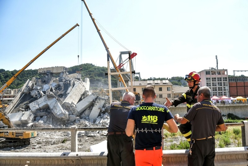 An Anpas Liguria volunteer distributes coffee to Italian fire fighters at the Morandi motorway bridge site three days after a section collapsed in the northwestern city Genoa on August 16, 2018. (AFP Photo)