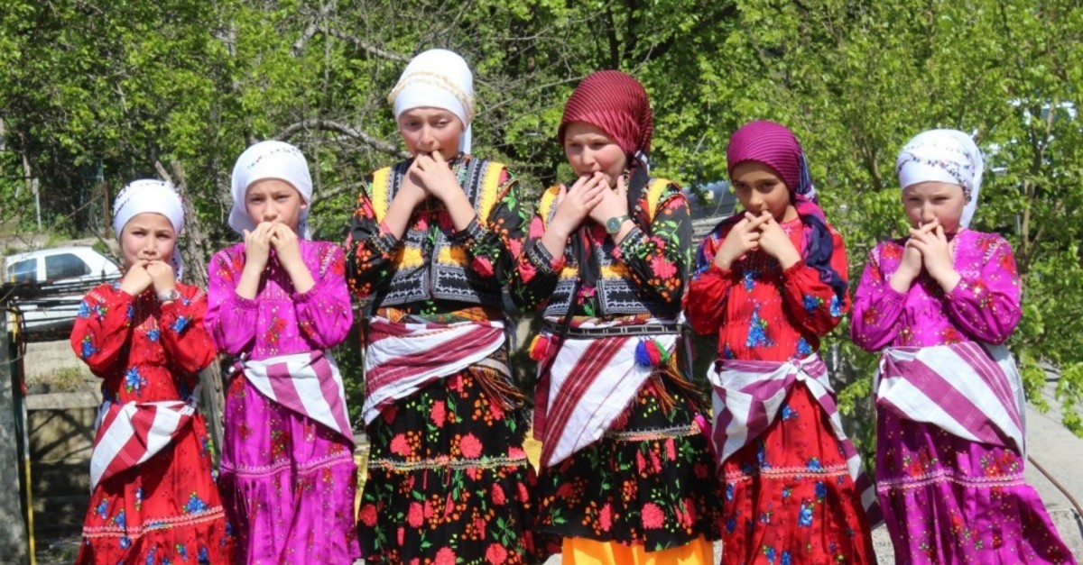 A group of children in traditional costumes gesture in ,kuu015fdili,, Giresun's whistled language, in this undated photo.