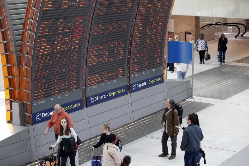 Travelers look at departure boards at Paris Charles de Gaulle airport, in Roissy, near Paris, Saturday, April 7, 2018. (AP Photo)