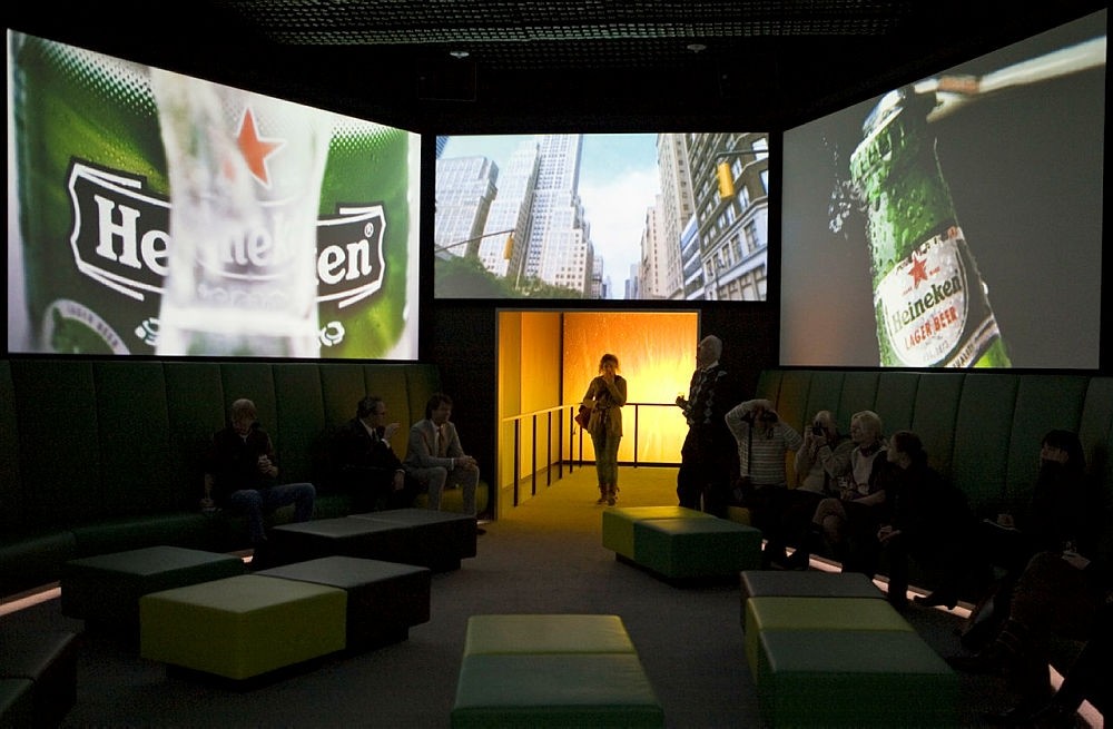In this Dec. 9, 2008, file photo, visitors watch Heineken commercials on large screens at the Heineken Experience, Amsterdam. (AP Photo)