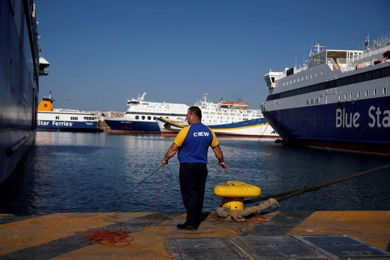 A seaman holds a rope next to a moored passenger ferry during a second consecutive 24-hour strike of Greece's seamen's federation PNO against austerity policies affecting their sector, at the port of Piraeus, Greece, Sept. 4, 2018. (Reuters Photo)
