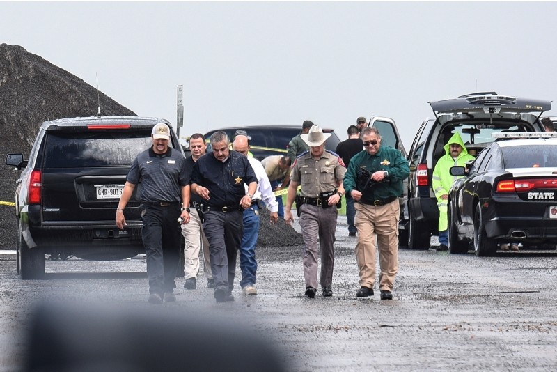 Law enforcement officers gather near the scene where the body of a woman was found near Interstate 35 north of Laredo, Texas on Saturday, Sept. 15, 2018. (AP Photo)