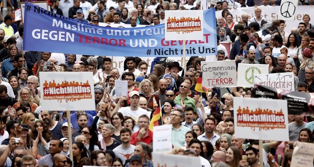 Participants carry a banner reading “Muslims and Friends against Terror and Violence” as they take part “The Not With Us” rally against the rising anti-Islam sentiment and extremism in Cologne, Germany, June 17.