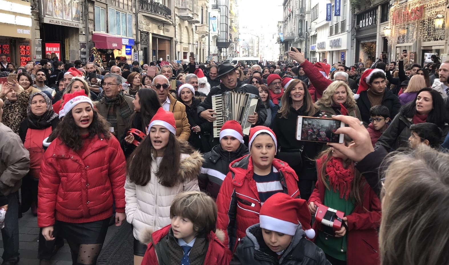 Children and adults sing carols on u0130stiklal Avenue.