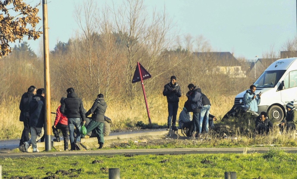 Migrants gather near a truck parking lot close to the N216 highway that leads to the ferry terminal, Calais, Jan. 12.