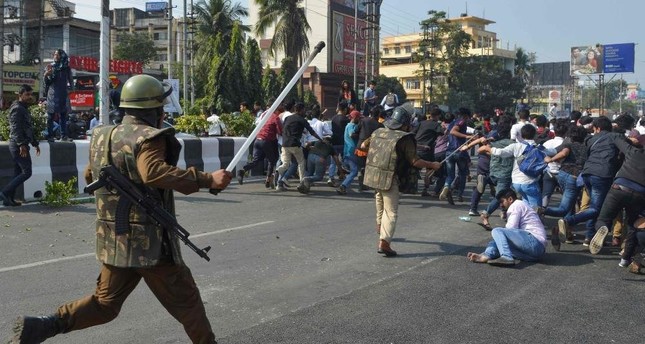 Security personnel use batons to disperse students protesting against the citizenship bill, Guwahati, Dec. 11, 2019. (AFP Photo)