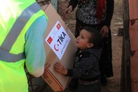A TIKA worker delivers aid to a family affected by floods in Tunisia's Ben Arous, Nov. 14, 2018. (COURTESY OF TIKA) 