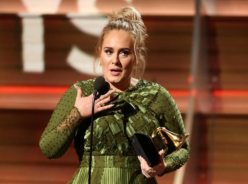 Adele and co-song writer Greg Kurstin (not pictured) accept the Grammy for Song of the Year for ,Hello, at the 59th Annual Grammy Awards in Los Angeles, California, U.S. (Reuters Photo)