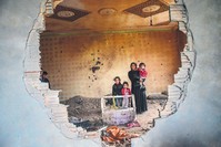 A woman and her children stand in the ruins of a house damaged by PKK terrorists clashing with security forces in the predominantly Kurdish town of Silopi, southeastern Turkey, January 19, 2016.