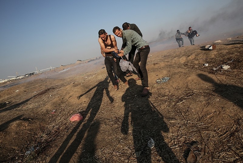 Palestinians protesters carry a wounded female protester during clashes near the border with Israel in the east of Gaza Strip, May 15, 2018. (EPA Photo) 