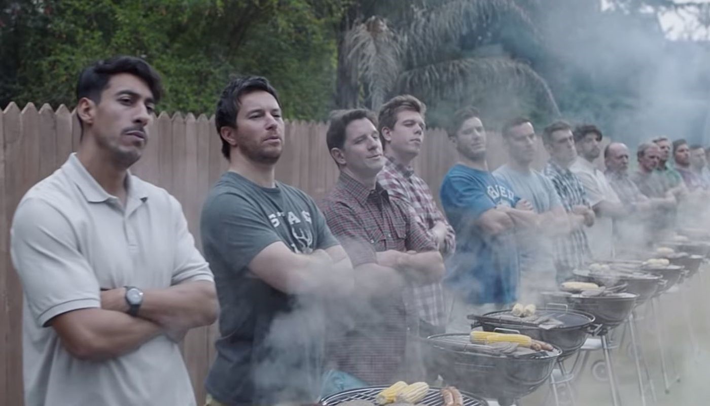 A screengrab from the new Gillette ad shows two kids wrestling while a long line of men stand in front.