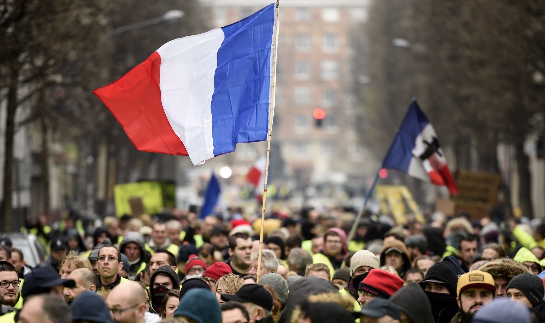 People hold up the French flag during a ,yellow vest, demonstration in the northern French city of Lille, Dec. 29. 