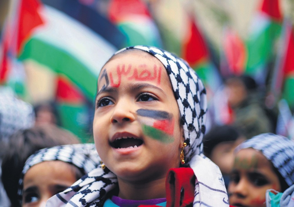 A girl with a Palestinian flag and ,Jerusalem is for us, painted on her face in Arabic, chants slogans during a sit-in in the Bourj al-Barajneh Palestinian refugee camp in Beirut, Lebanon Dec. 6.
