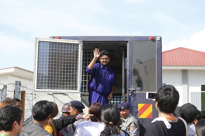 Myanmar freelance journalist Aung Naing Soe waves to his family from a prison van as he leaves after a hearing on his trial at Zabu Thiri Court in Naypyitaw, Myanmar, Nov. 16, 2017. (EPA Photo)