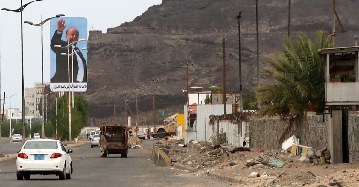 Cars drive beneath a large billboard showing Yemen's internationally recognized government of President Abed Rabbo Manour Hadi, Aden, Aug. 17, 2019.