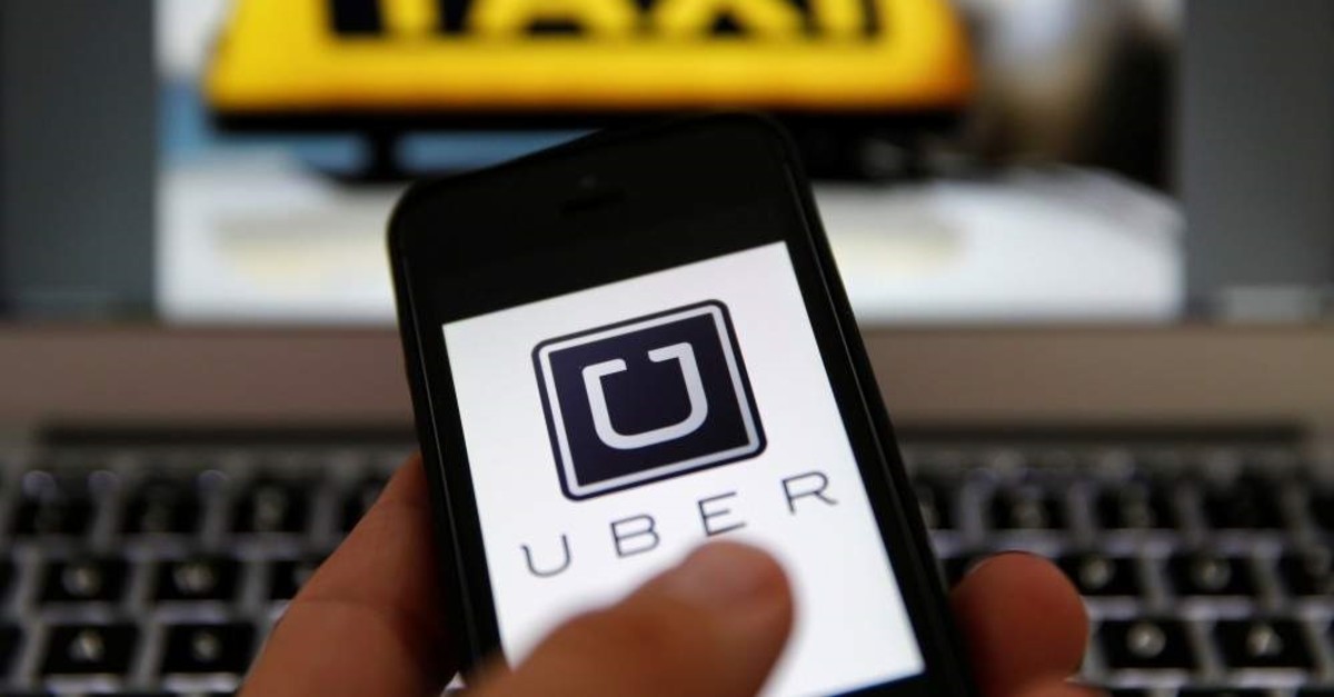 FILE PHOTO: An illustration picture shows the logo of the car-sharing service app Uber on a smartphone next to the picture of an official German taxi sign in Frankfurt, Sept. 15, 2014. (Reuters Photo)