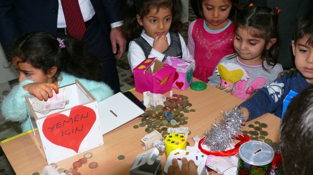 Children in the Yeu015filyurt district of Tokat province hand out money they collected from their allowances to officials for the Yemen aid campaign yesterday.