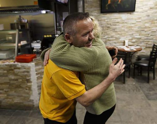 Kaşıkçıoğlu gets a hug from Grace Williams, a fourth-floor resident, after he ran to save people from an apartment building in Edmonton, Alberta on Thursday, Jan. 19, 2017. (Post Media Photo)