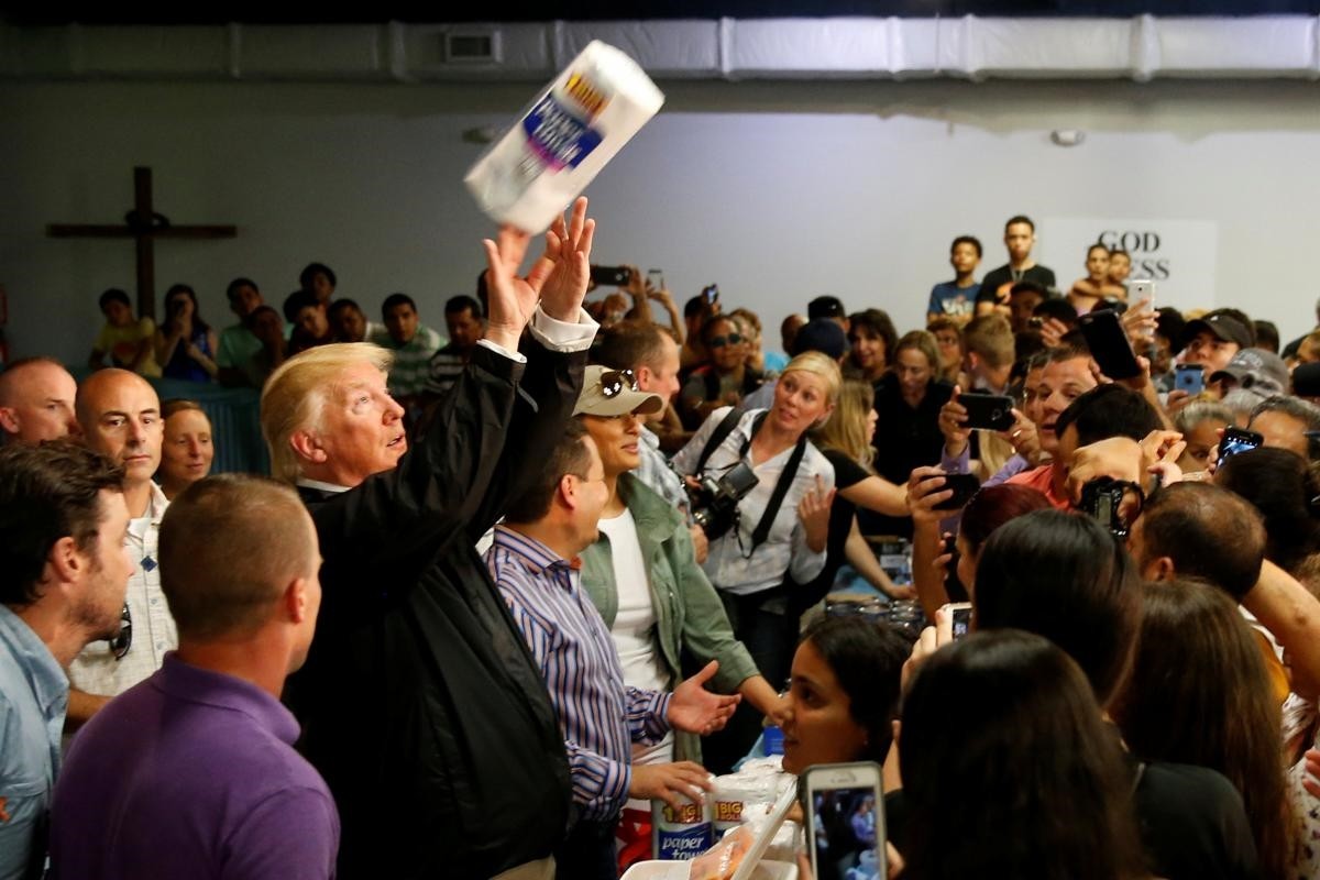 U.S. President Donald Trump tosses rolls of paper towels to people at a hurricane relief distribution center at Calvary Chapel in San Juan, Puerto Rico, October 3, 2017. (REUTERS)