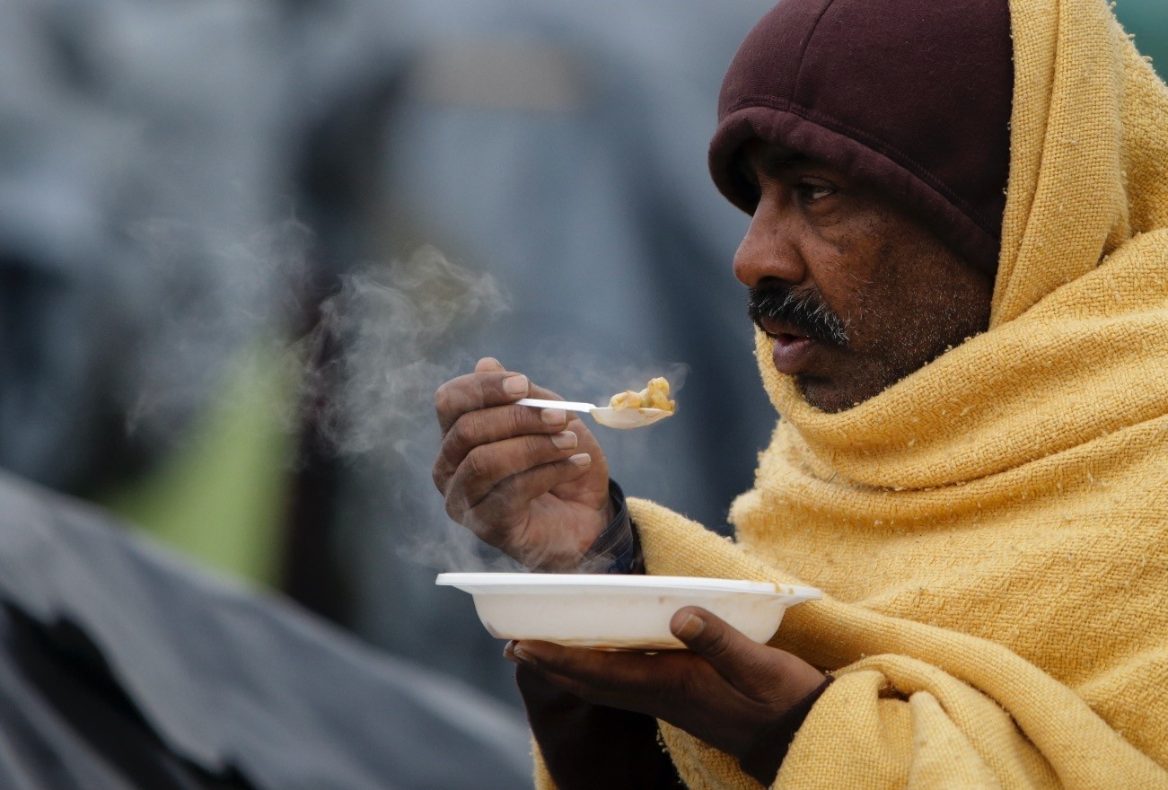 A migrant eats a meal at a makeshift camp in Velika Kladusa, Bosnia-Herzegovina, Nov. 18.