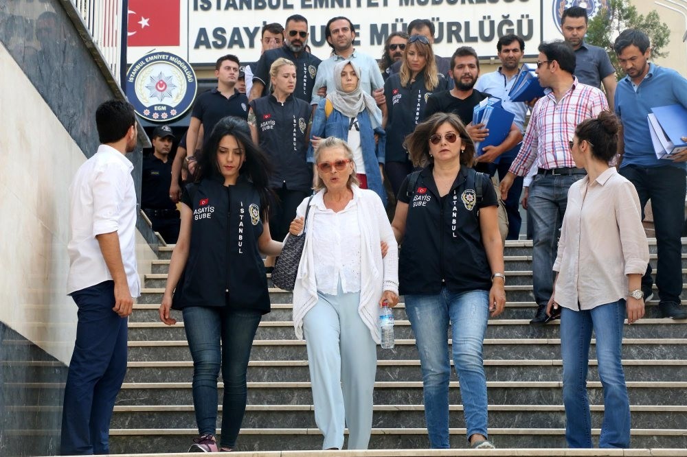 Officers escort Nazlu0131 Ilu0131cak as she leaves a police station for prison after her detention last year.