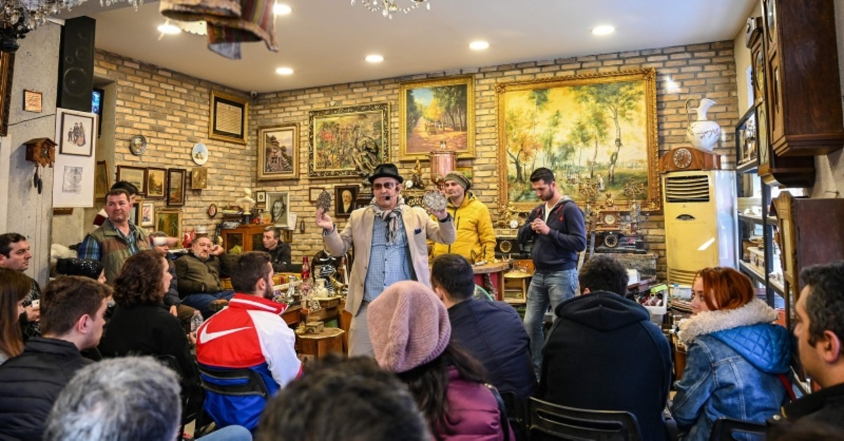 Auctioneer Ali Tuna (C) shows items to the audience at an auction house in Istanbul's Balat district on February 3, 2019. (AFP Photo)