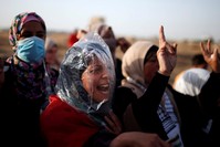 A female demonstrator wearing a plastic bag chants slogans during a protest where Palestinians demand the right to return to their homeland, at the Gaza Strip, east of Gaza City, May 18.