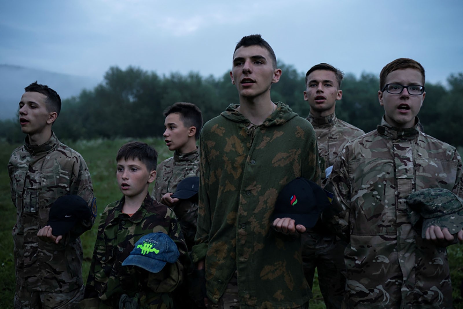 Mykhailo, 18, center, leads other young participants of the camp as they stand in formation singing nationalist songs.