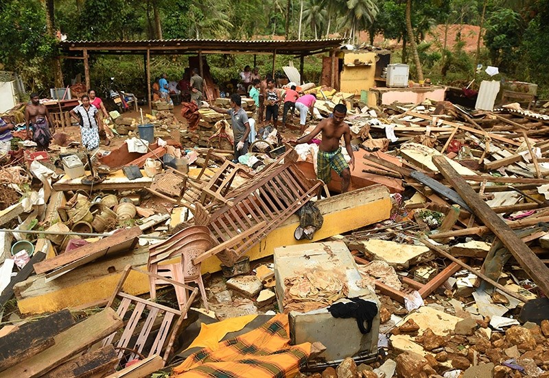 Sri Lankan residents walk among damaged homes following flooding in Yatagampitiya village in Bulathsinhala on June 2, 2017. (AFP Photo)