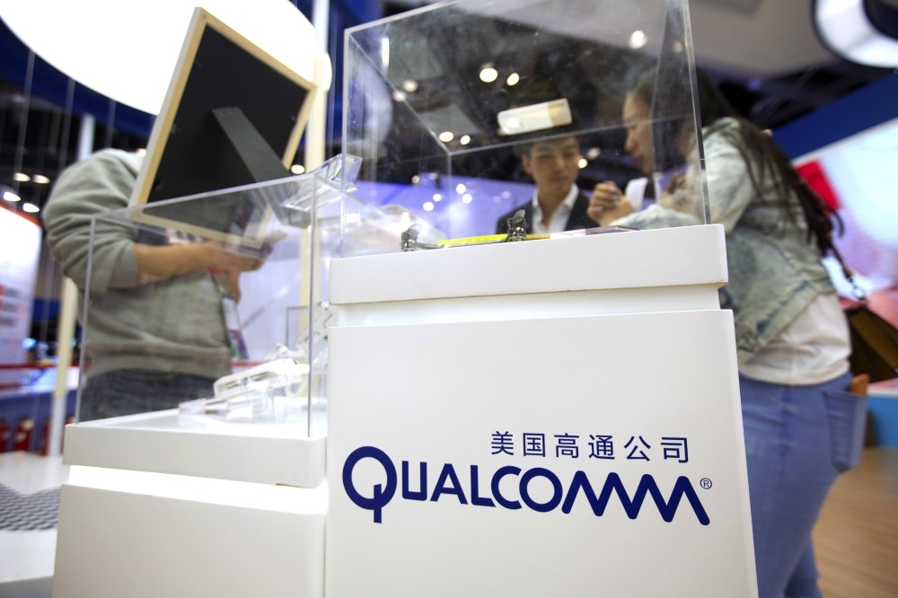 Visitors look at a display booth for Qualcomm at the Global Mobile Internet Conference (GMIC) in Beijing.