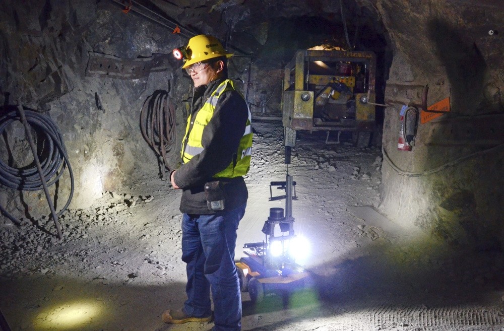 A miner is backed by a robot in the Edgar Mine near Denver.