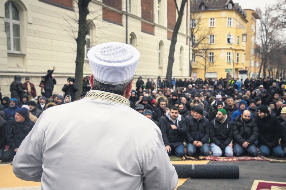 A Turkish imam addresses the Turkish-German community prior to the Friday prayer, in the street in front of the Koca Sinan Mosque, Berlin, March 16. 