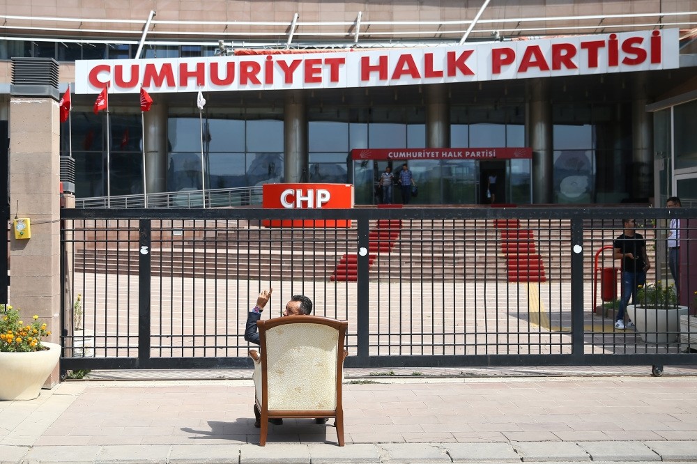 A party member protests Kemal Ku0131lu0131u00e7darou011flu's one-man rule in the party by sitting on a chair in front of the CHP headquarters in Ankara, Aug. 8.