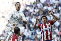Real Madridu2019s Portuguese striker Cristiano Ronaldo (L) tries to score next to Uruguayan defender Diego Godin (C) of Atletico Madrid during the Primera Division match at Santiago Bernabeu stadium in Madrid on Apr. 8.