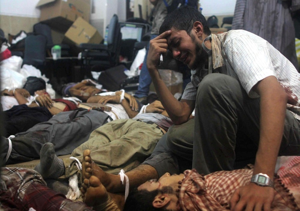 A man grieves as he looks at one of many bodies laid out in a make shift morgue after Egyptian security forces stormed two huge protest camps at the Rabaa al-Adawiya square. (AFP Photo)