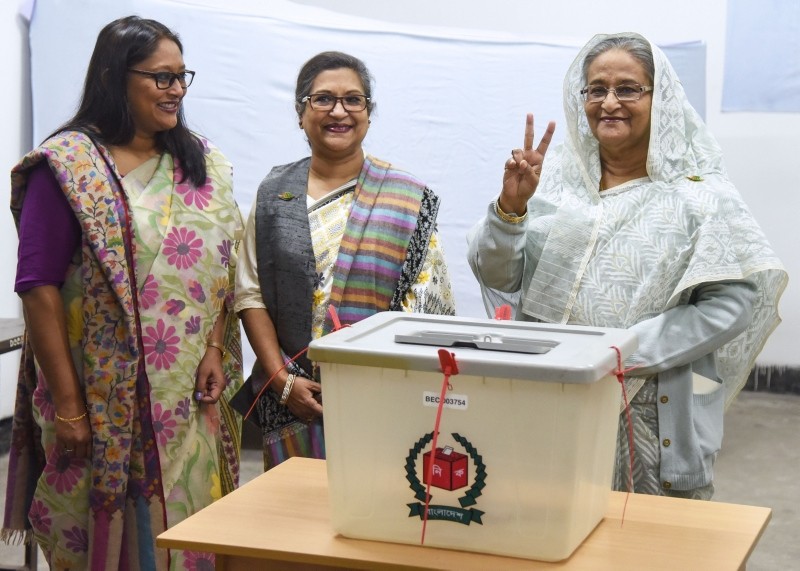 Bangladeshi Prime Minister Sheikh Hasina (R) flashes the victory symbol after casting her vote, as her daughter Saima Wazed Hossain (1st L) and her sister Sheikh Rehana (2nd L) look on at a polling station in Dhaka on December 30, 2018. (AFP Photo)