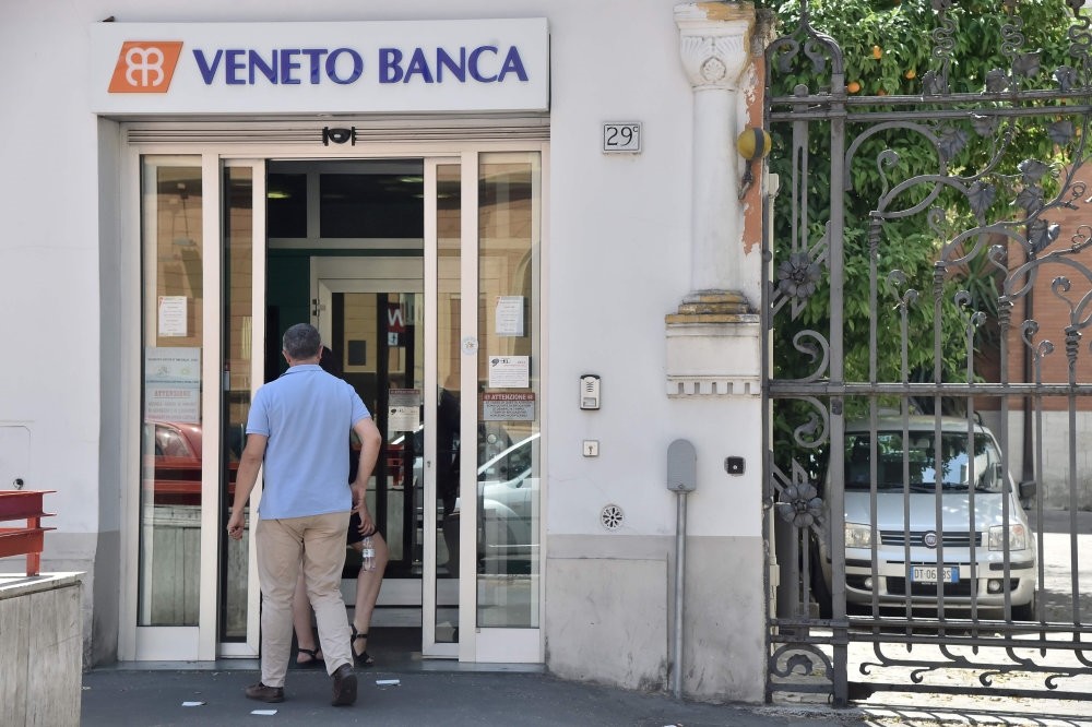 A man enters a branch of Italian bank Veneto Banca in Rome.