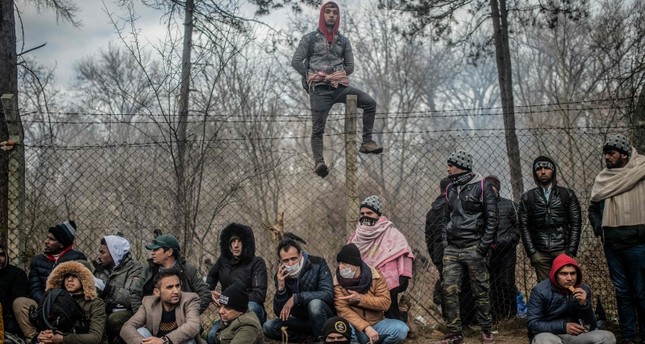 مجموعة من المهاجرين ينتظرون أمام المنطقة الفاصلة بين الحدود التركية- اليونانية بولاية أدرنة شمال غربي تركيا وكالة الأنباء الفرنسية