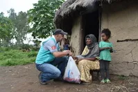 A volunteer from Turkish charity Cansuyu delivers food aid to a woman in a village in Ethiophia's Hadiya, Aug. 12, 2019.