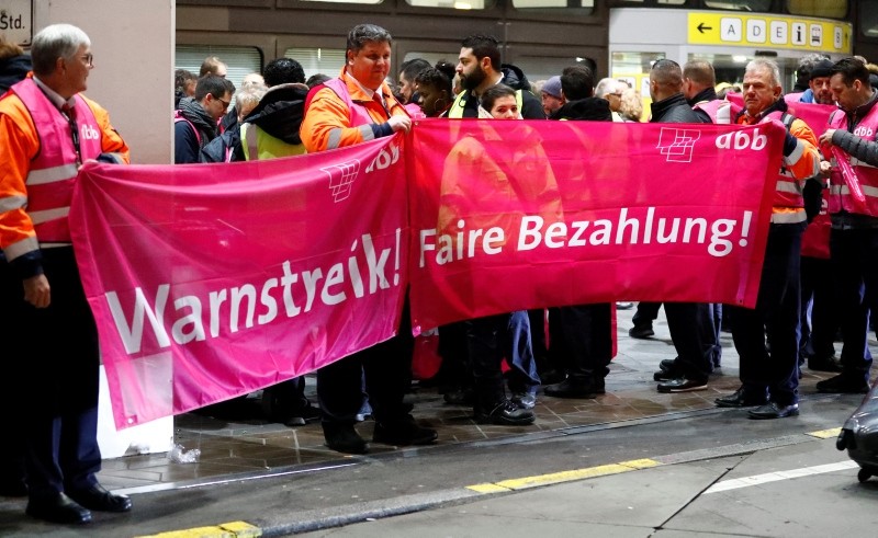 Members of Germany's Verdi union take part in a strike by ground security inspection staff at Tegel airport in Berlin, Germany, Jan. 7, 2019. The banners read ,Warning strike! Better payment., (Reuters Photo)