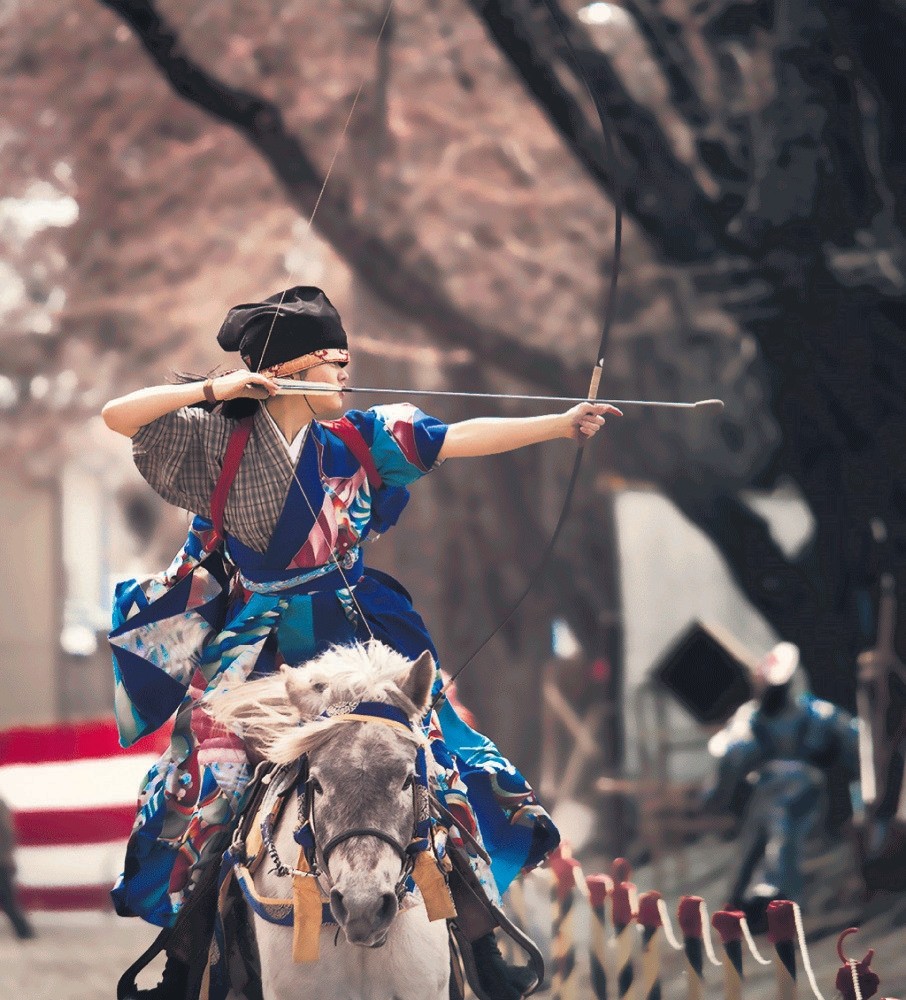 Aiming at three wooden targets, Japanese archers try to hit them with their turnip-headed arrows using yumi bows.