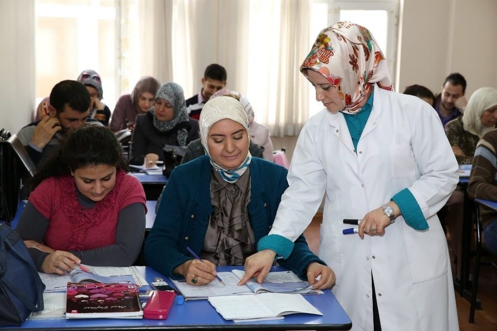 A teacher helps Wafa Mourad, a Syrian woman, in a Turkish class run by a local municipality in Istanbul.