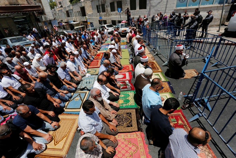 Palestinian Muslims pray outside the old city walls after Israeli police block access to the Al-Aqsa mosque in Jerusalem on Friday, July 14, 2017. (AA Photo)