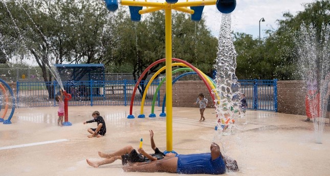 السكان يمرحون بالمياه في متنزه براندي فنتون التذكاري خلال موجة حر شديد في توكسون، أريزونا، الولايات المتحدة،  15-7-2023 صورة: AFP