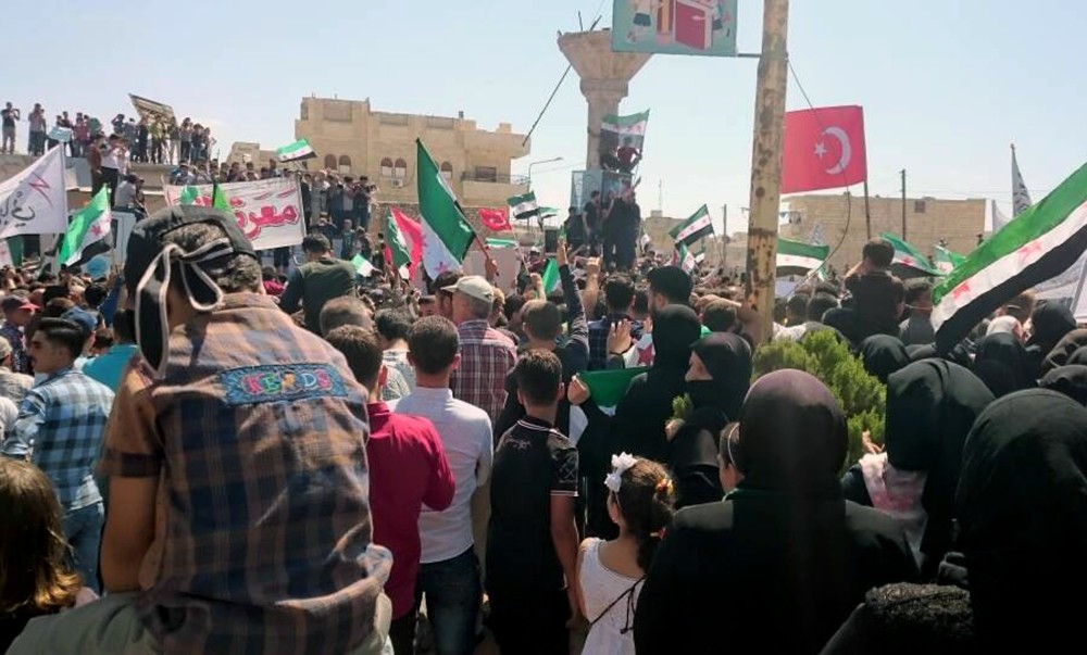 This image courtesy of Wissam Zarqa, a resident of Idlib, shows protesters holding Turkish flags and the flags of the Syrian revolution u0130Qin Idlib province, Syria, Friday.