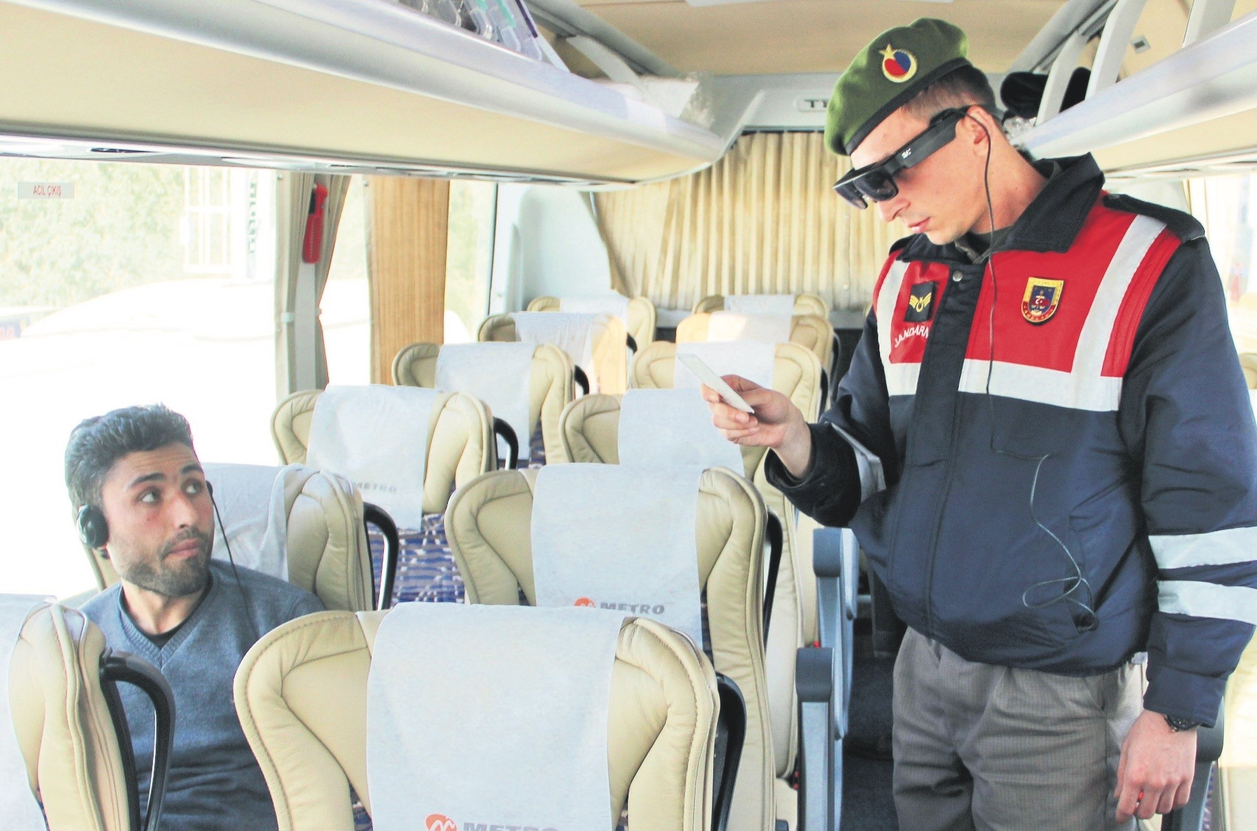  A gendarme checks the ID of a bus passenger with Takbul goggles.