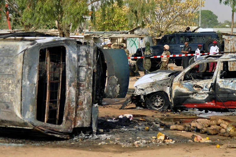 In this Feb. 24, 2015 file photo, police officers stand guard following a Boko Haram suicide bomb explosion at a bus station in Kano, Nigeria. (AP Photo)
