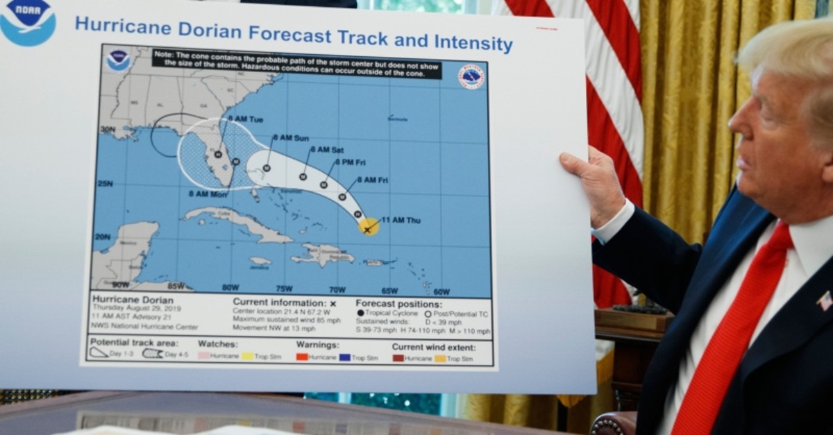 U.S. President Donald Trump holds a chart as he talks with reporters after receiving a briefing on Hurricane Dorian in the Oval Office of the White House, Wednesday, Sept. 4, 2019, in Washington. (AP Photo)