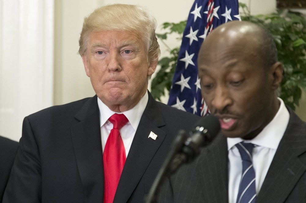 U.S. President Donald J. Trump (L) listens to Merck CEO Kenneth Frazier (R) speak during the announcement of a pharmaceutical glass packaging initiative at the White House, Washington.