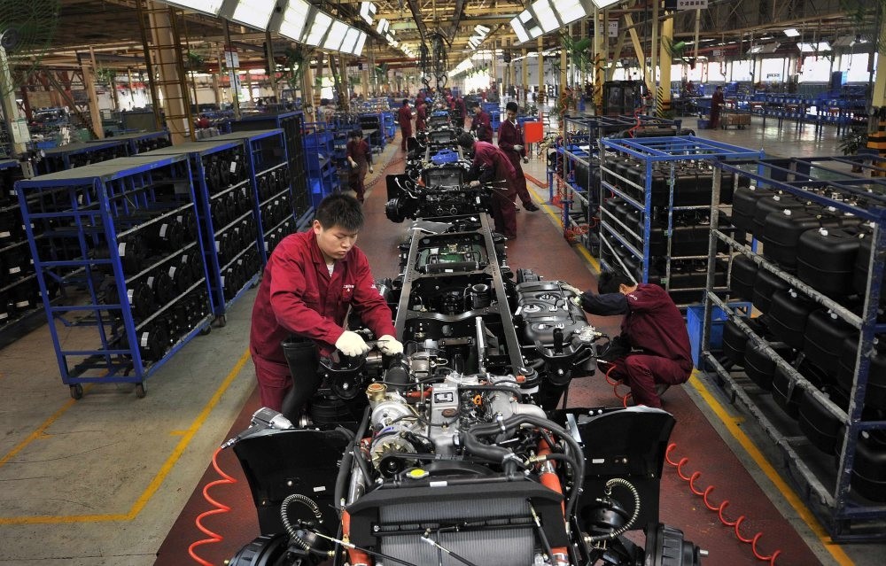 Workers install the chassis along a production line at a truck factory in Hefei, Anhui province, China.  